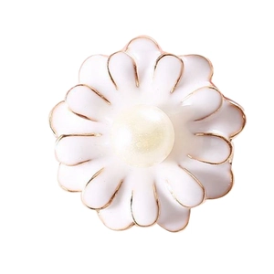 Elegante accessorio a fiore in smalto bianco con bordo dorato e perla centrale