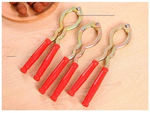 Detailed view of metal nutcrackers with red plastic handles on a wooden background