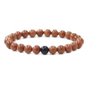 Matching 8mm distance beads bracelet in brown goldstone with a single blue accent stone