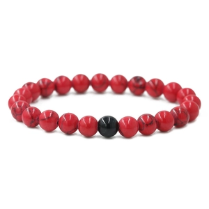 Close-up of 8mm red turquoise beaded distance bracelet with a single black accent bead