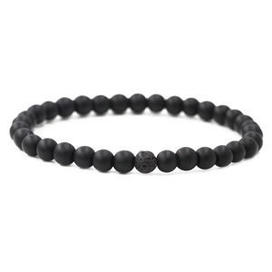 Detail of 6mm matte black beads and porous volcanic stone on elastic distance bracelet