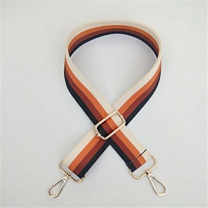 Close-up of a wide woven colorful striped replacement bag strap with golden metal hooks