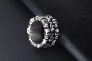 Detailed close-up of a silver skull-engraved titanium ring for men on leather