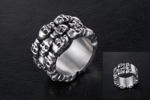 Macro shot of polished titanium steel ring with stacked 3D skull details on black leather