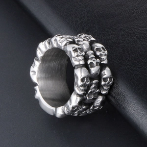 Men's gothic stainless steel ring with detailed skull carvings on black leather background