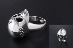 Macro side view of polished silver skull ring with gothic rock and punk style details