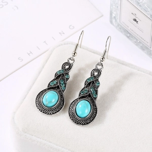 Vue détaillée de boucles d'oreilles bohèmes avec pierres turquoise et cristaux verts