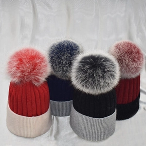 Selection of knit beanies with faux fur pom-poms in four distinct color combinations