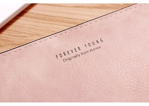 Macro detail of pink leather wallet showing neat stitching and Forever Young brand embossing
