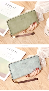 Detail of long zippered wallets in green and blue faux suede with detachable wrist straps