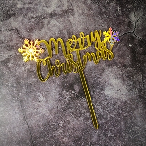 Golden Merry Christmas cake topper with colorful snowflakes on dark background