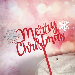 Detail of red Merry Christmas cake topper with silver snowflakes on festive background