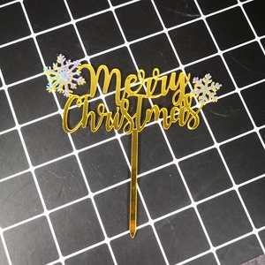 Close-up of golden acrylic Merry Christmas cake topper with colorful snowflake decor