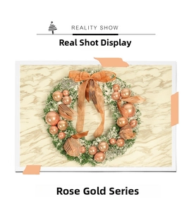 Detail of rose gold ornaments and white flocked snow on Christmas wreath decorations
