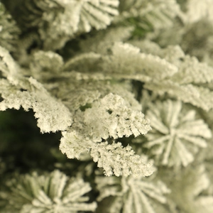 Close-up of high-density flocked snow on green PVC pine needles for Christmas tree decor