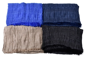 Flat lay of men's scarves in blue, beige, and black with crinkle texture and fringe