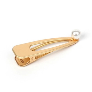 Detailed view of a golden metal hair clip with an elegant white pearl accent on a white background