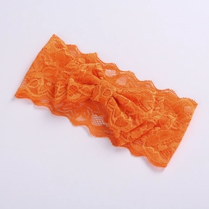 Close-up of an orange lace headband featuring a delicate double-layered bow design