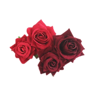 Detailed view of red and burgundy velvet artificial rose heads for bridal hair accessories