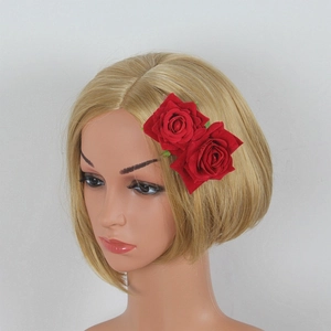 Detail view of double red velvet rose hair clips on a mannequin for vintage bridal styling