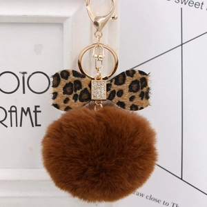 Close-up of brown faux fur pompom keychain with leopard bow and rhinestone details