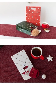 Close-up of festive Merry Christmas gift bags and matching socks with holiday decor