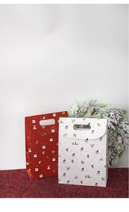 Close-up of red and white Christmas paper gift bags with cartoon holiday illustrations