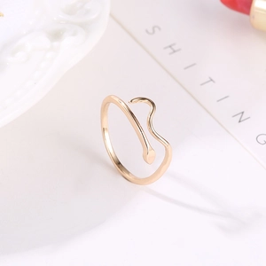 Close-up of golden adjustable snake ring featuring a minimalist head and tail design