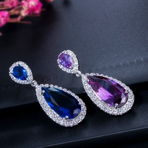 Macro shot of silver teardrop earrings featuring blue and purple zircon with micro-pave setting