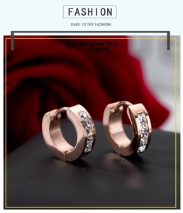 Macro view of rose gold titanium earrings with square-cut white zircons on black stand