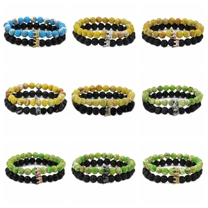 Detail of nine crown charm beaded bracelets featuring lava stone and natural gemstones