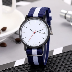 Minimalist men's watch with white dial, blue and white striped nylon strap in lifestyle setting