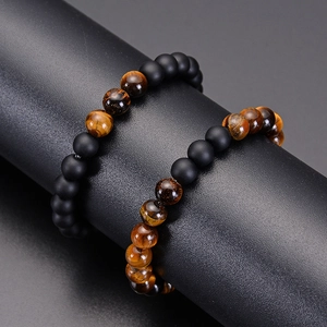 Detail of 8mm tiger eye and matte black stone beaded bracelets on a display stand