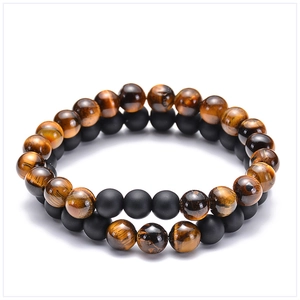 Close-up of 8mm tiger eye and matte black stone beaded bracelets set on white background