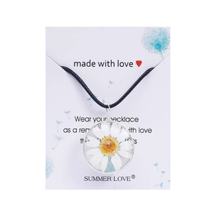 Detailed close-up of a transparent glass pendant featuring a real white daisy flower inside