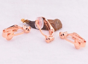 Detail of rose gold U-shape earring converter with silicone pad on white fabric