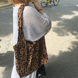 Detailed view of the wide shoulder strap and fabric texture of leopard print tote bag