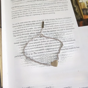 Minimalist 925 silver heart charm chain bracelet displayed on an open art book