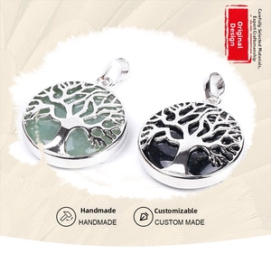 Detailed view of handmade Tree of Life pendants in silver frame with green and blue stones