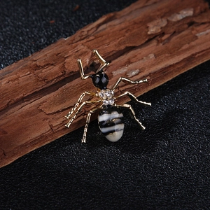 Broche fourmi dorée avec émail noir et cristaux blancs sur bois naturel rustique