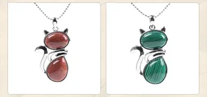 Detailed view of cat-shaped stone pendants in goldstone and malachite with silver chains
