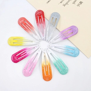 Top view of ten colorful glitter gradient metal BB hair clips arranged in a circular layout