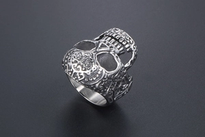 Macro detail of retro gothic skull ring showing intricate vintage metal textures