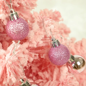 Close-up of pink glitter and silver shiny Christmas ball ornaments with hanging strings