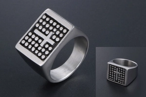 Detailed macro of vintage stainless steel signet ring with embossed cross and dotted pattern