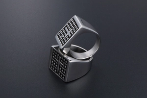 Macro view of vintage stainless steel rings showing cross patterns and dot matrix details
