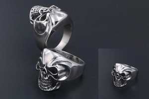 Detailed macro view of a silver titanium steel skull ring with intricate facial carvings