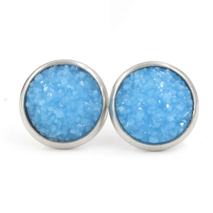 Vue détaillée de boucles d'oreilles rondes en résine bleue à texture scintillante