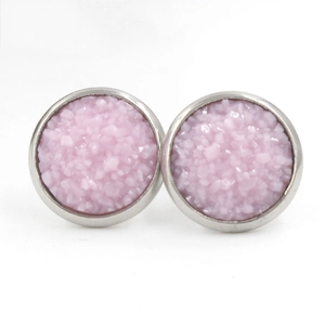 Détail de boucles d'oreilles roses en résine avec base en métal argenté sur blanc