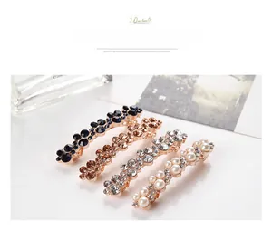 Detailed view of four Korean style pearl and rhinestone hair clips in gold finish